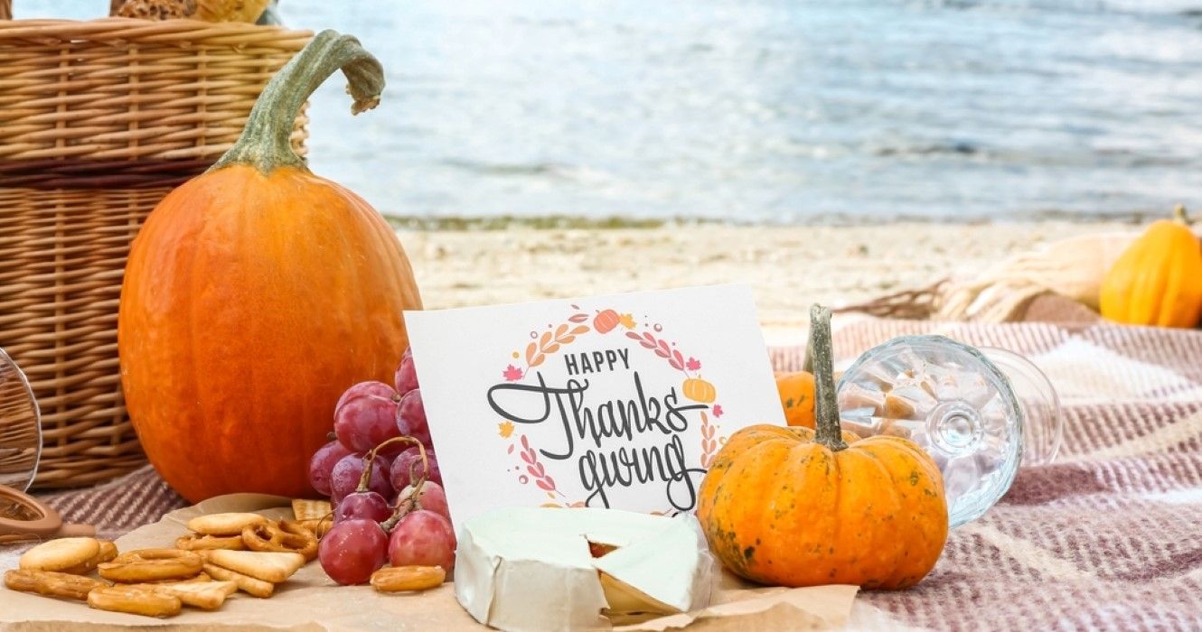 Abóbora, queijo e cartão com texto HAPPY THANKSGIVING na praia