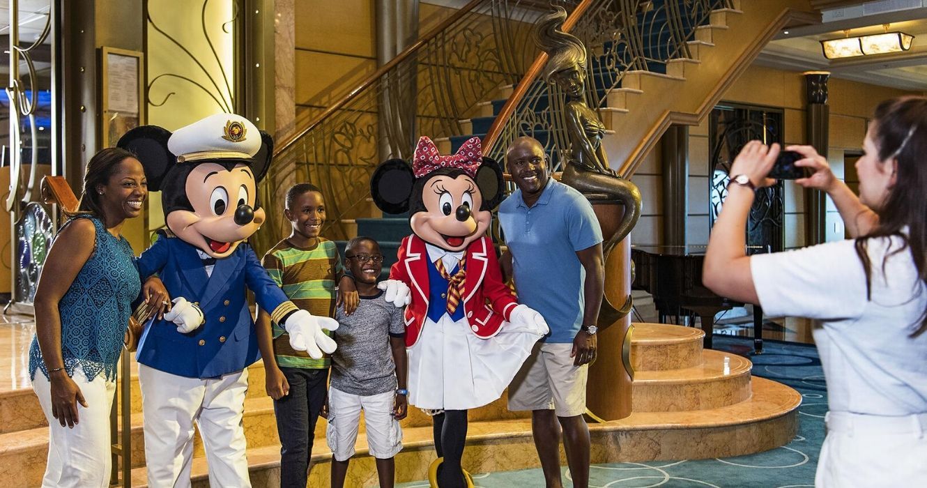 16 coisas que a equipe disse sobre trabalhar a bordo dos cruzeiros da Disney 3 uma família tira uma foto com mickey e minnie mouse a bordo de um cruzeiro da disney